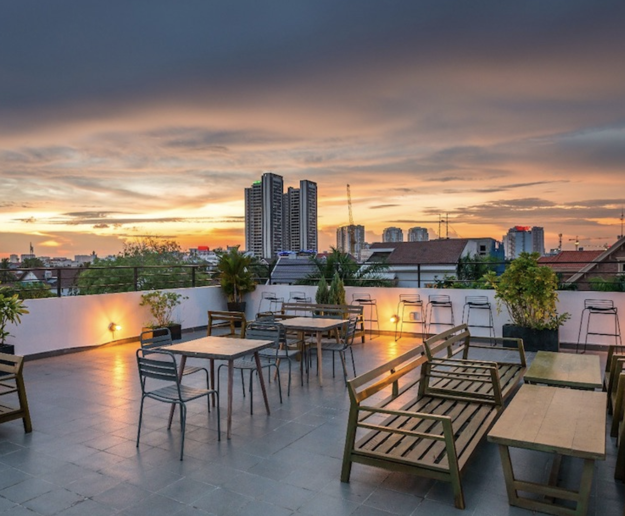 The Hive rooftop at dusk, tables and benches with Saigon skyline