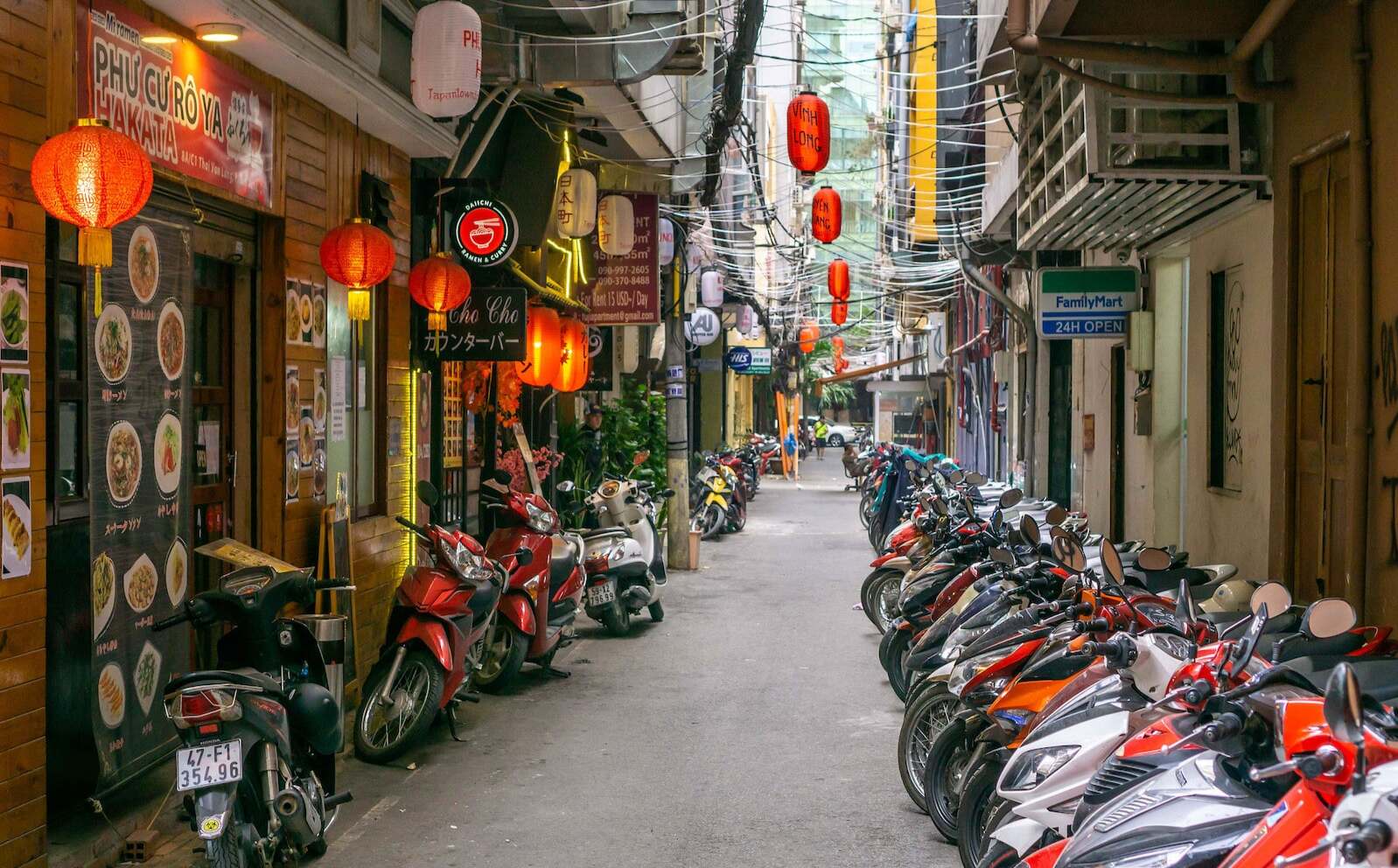 Little Tokyo alley off Lê Thánh Tôn with red lanterns, Japanese signs, and parked motorbikes