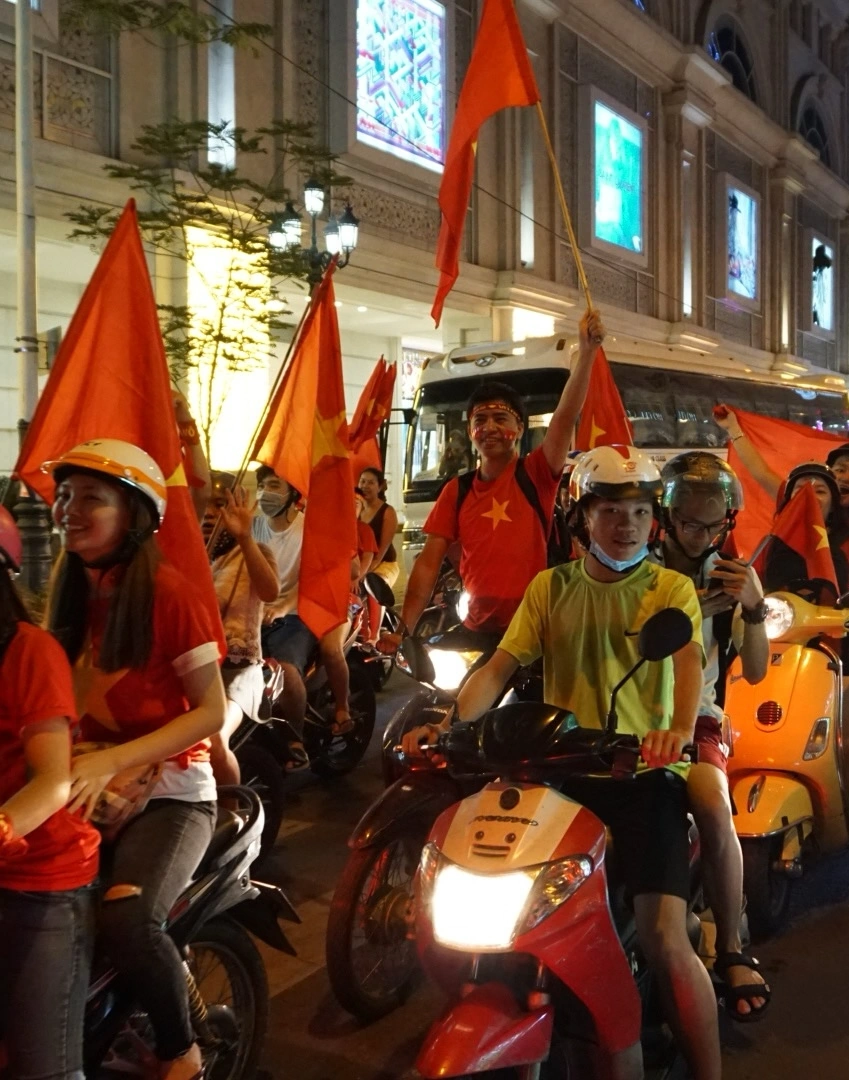 Motorbike column with red flags celebrating a Vietnam football win in District 1